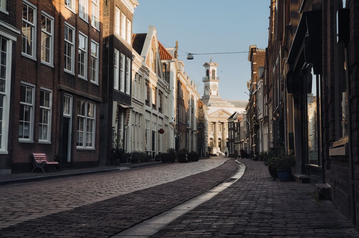 Picturesque street view of historic Dordrecht, Netherlands with classic architecture and morning sun.