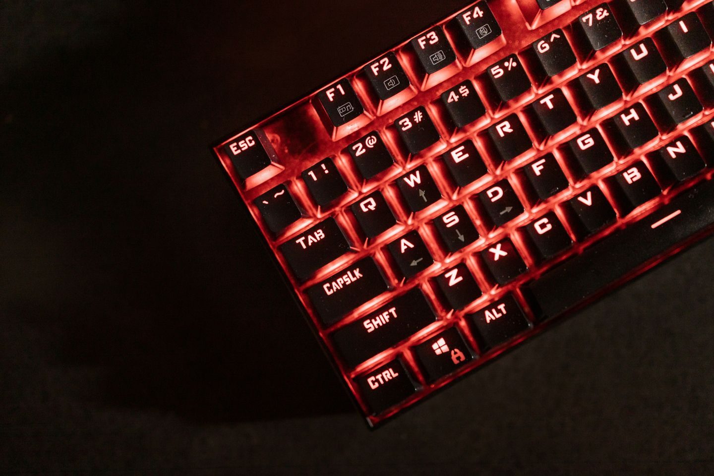 Photograph: Close-up view of a red illuminated mechanical gaming keyboard in a dark room.